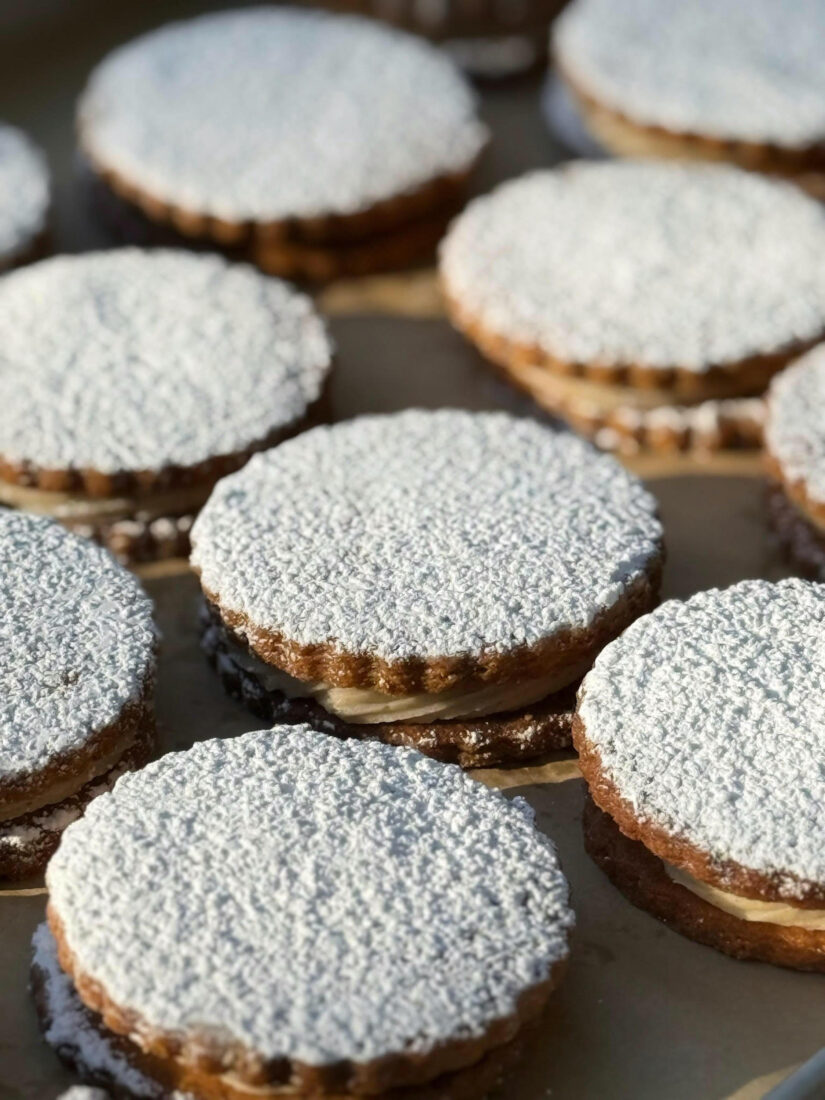 A tray of sandwich cookies dusted with sugar