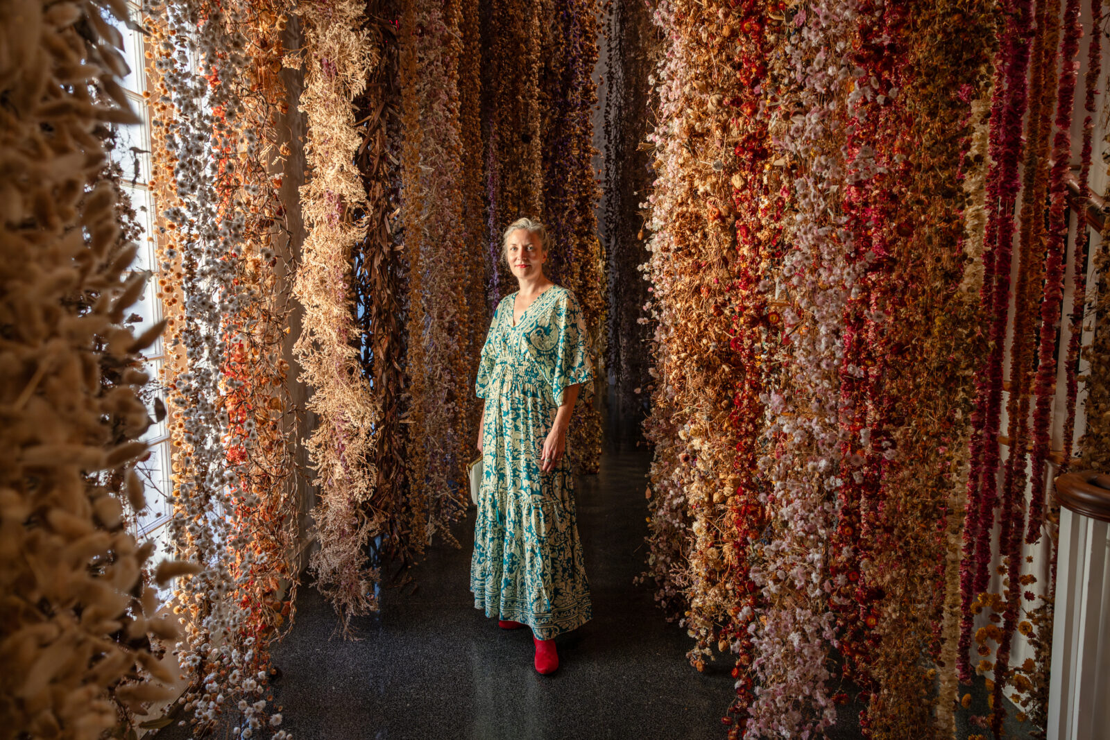 A woman stands in a gallery of flowers