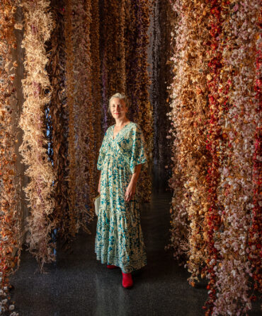 A woman stands in a gallery of flowers