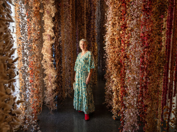 A woman stands in a gallery of flowers
