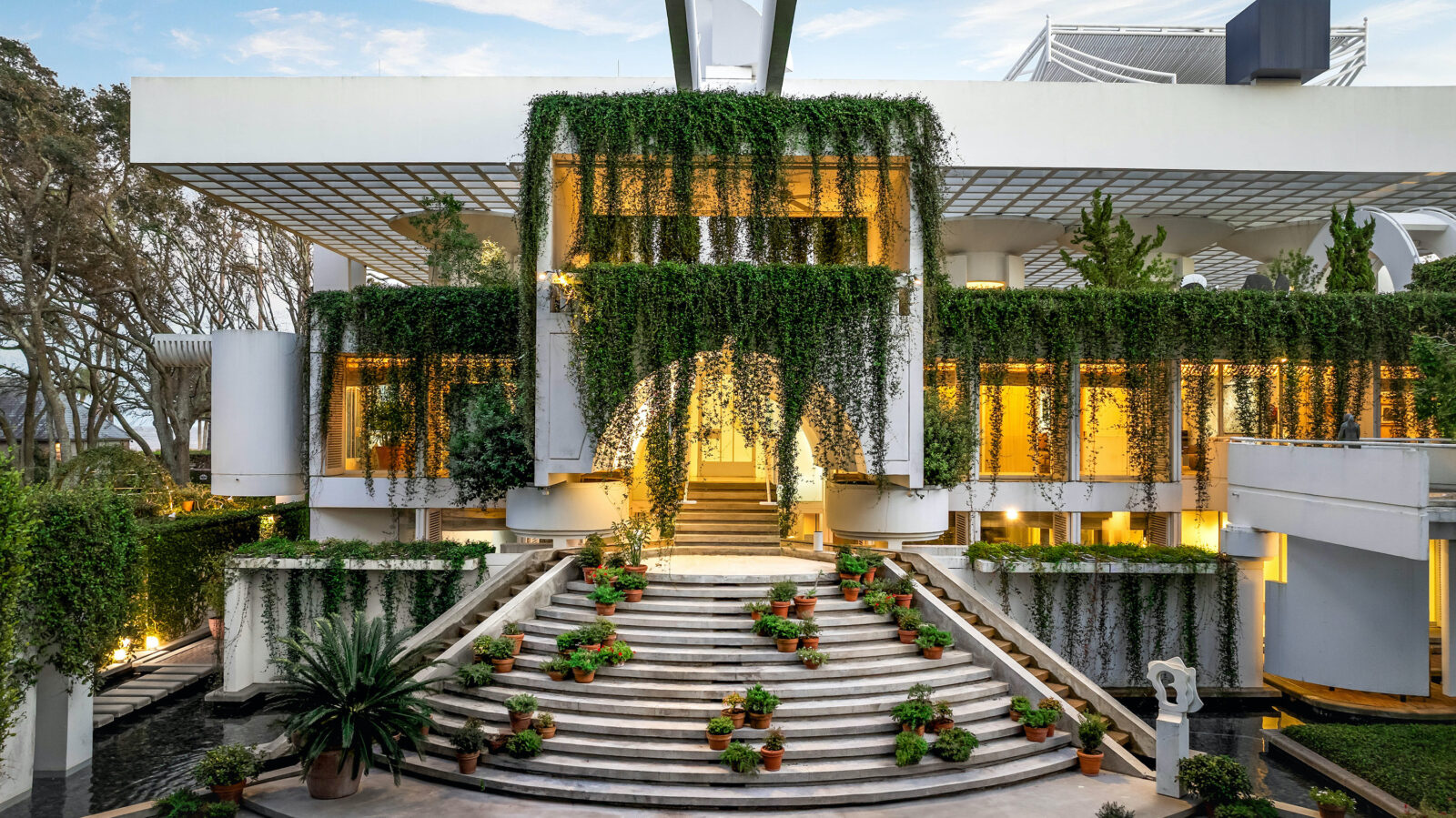 The front of a mansion with greenery