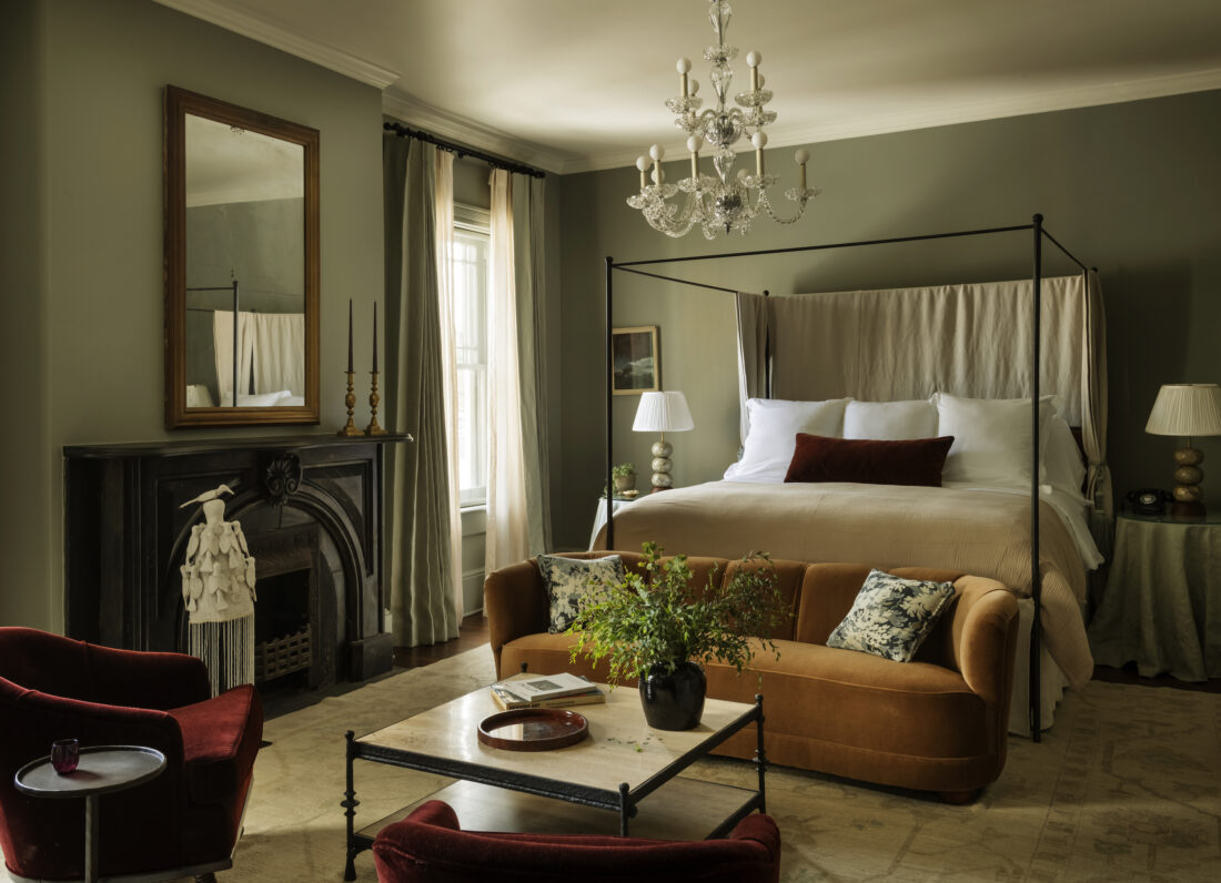 A green guest room with a fireplace