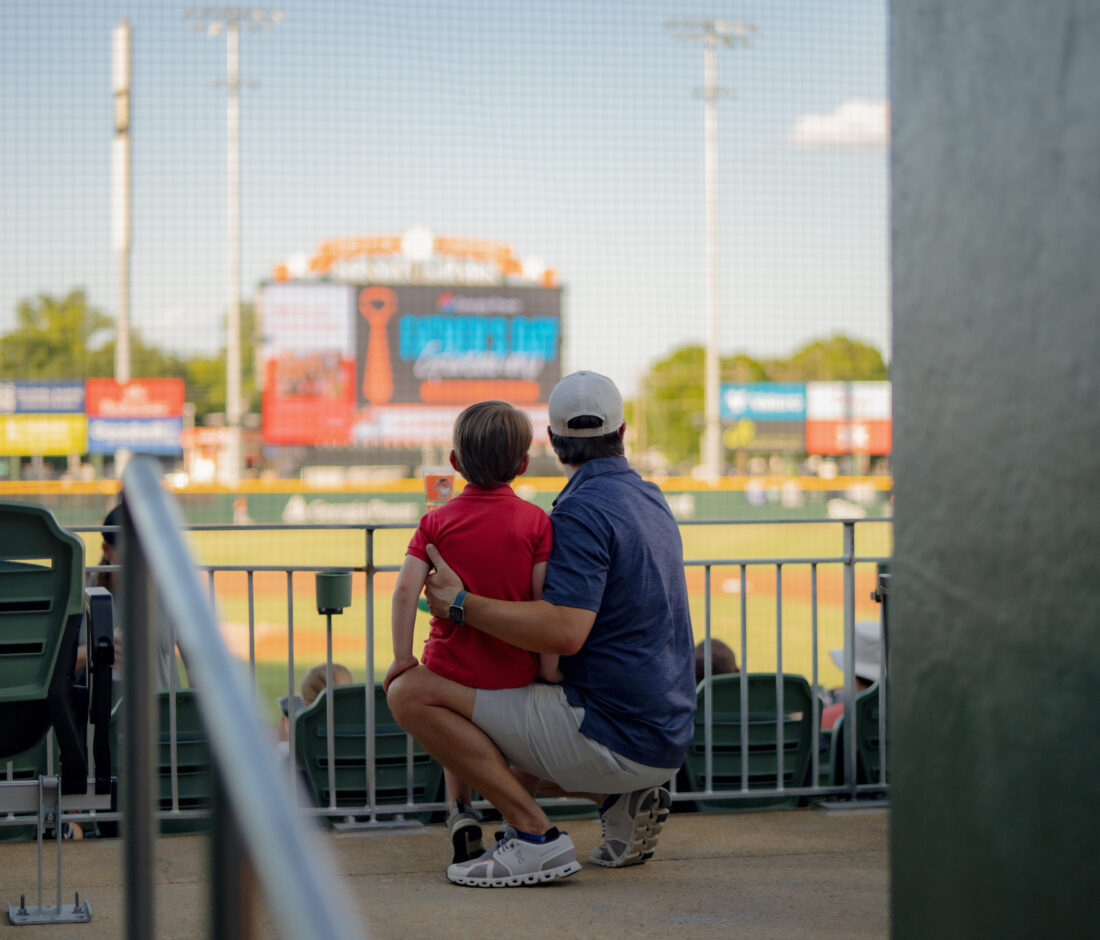 A boy and father at a baseball stadium