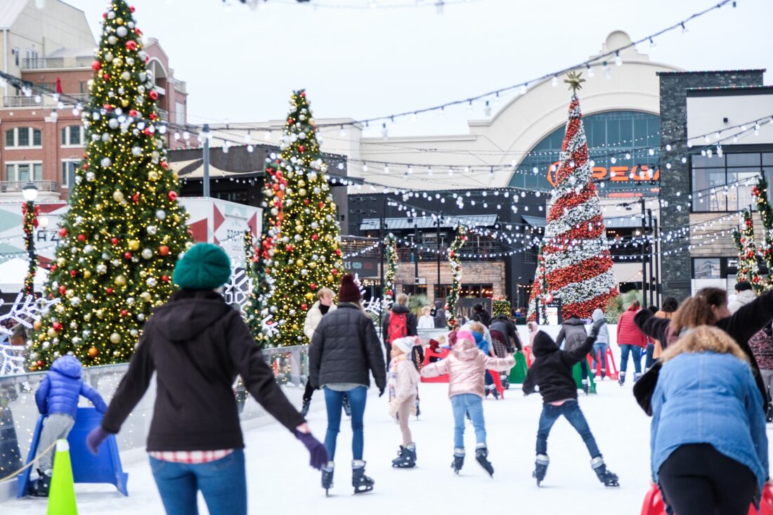 Skaters on a rink with Christmas trees