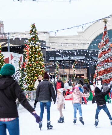 Skaters on a rink with Christmas trees