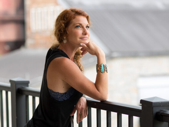 A woman leaning on a railing at a distillery
