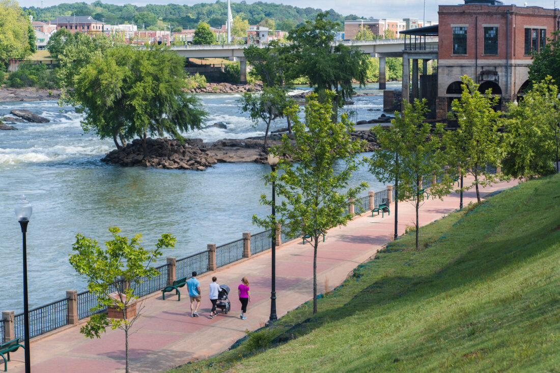 People walk along a river