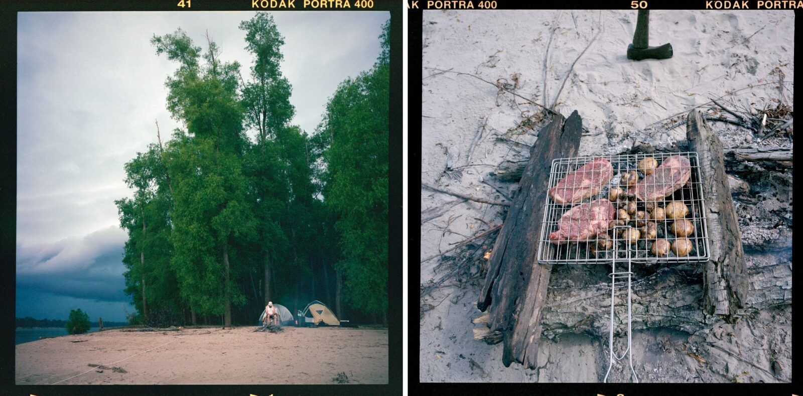 People set up a tent on a river island; steak and potatoes over a fire