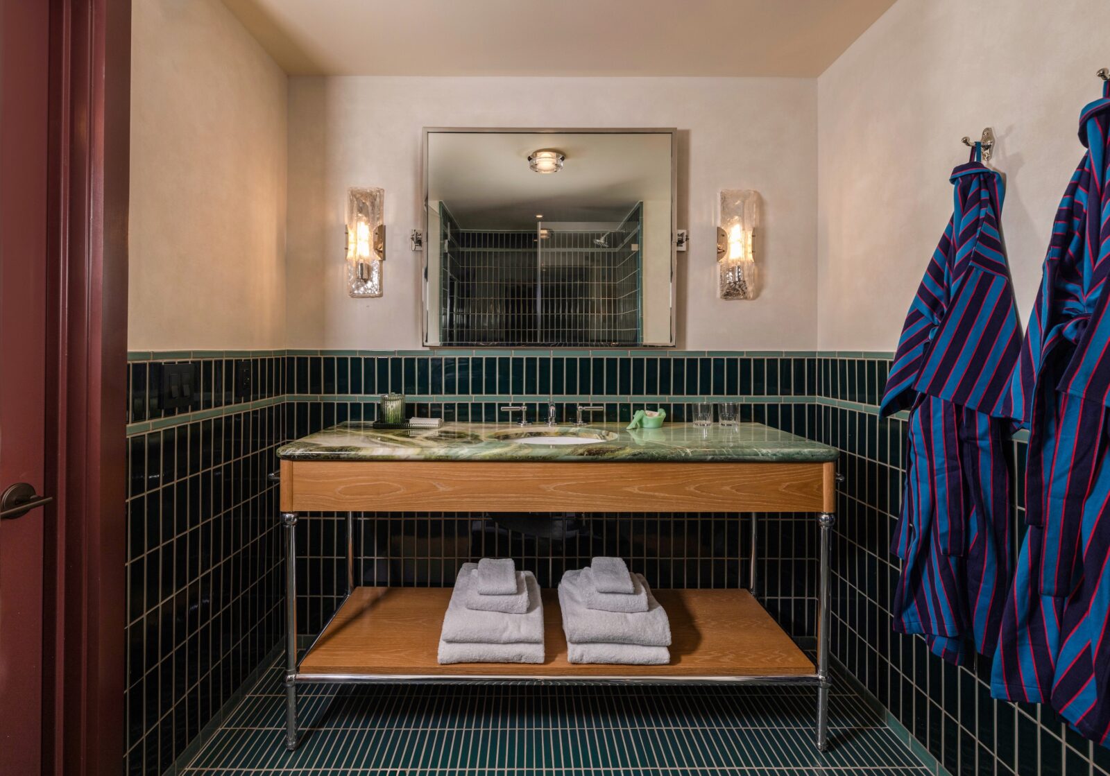 A dark green tiled bathroom