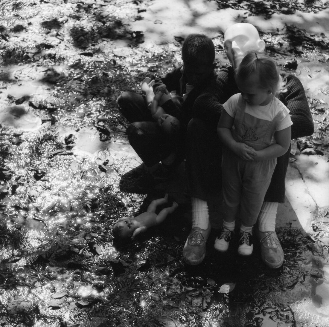 A black and white photo of a man and two children with masks