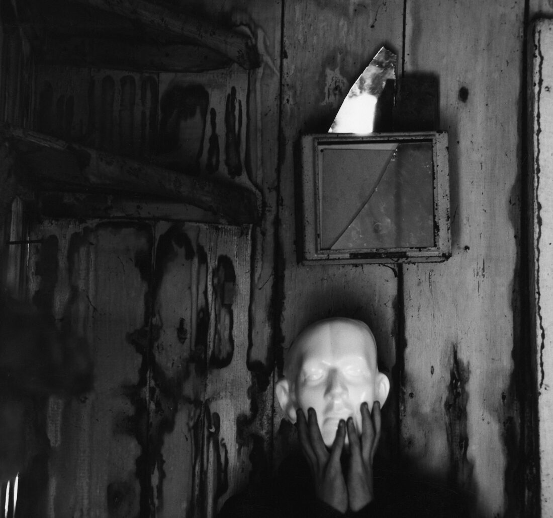 A hand holds up a mask