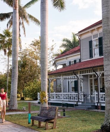 A group of people walk by a historic home
