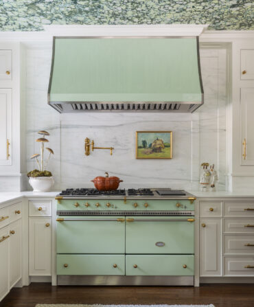 A kitchen with a mint green range and marbled ceiling