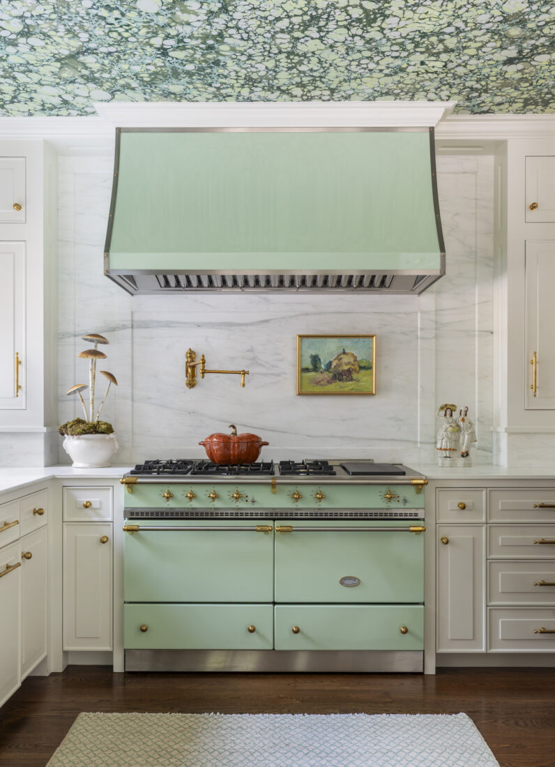 A kitchen with a mint green range and marbled ceiling