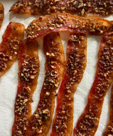 Bacon candied with brown sugar-bacon syrup, black pepper, and chopped pecans