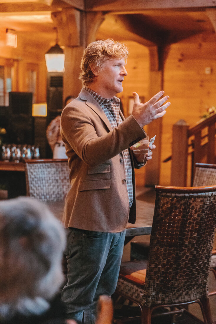A man stands to speak at an event