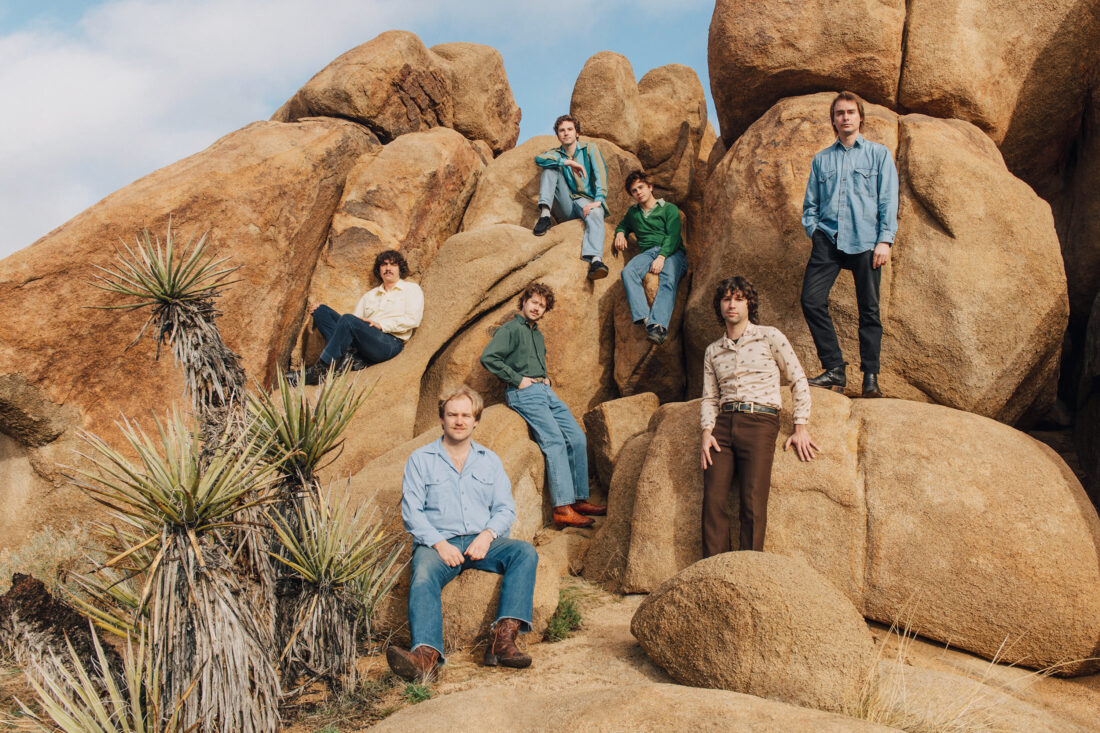 Band members sit on rocks in Joshua Tree