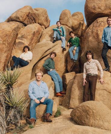 Band members sit on rocks in Joshua Tree