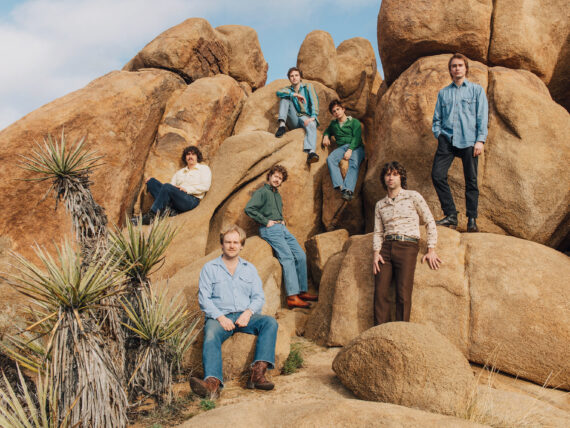 Band members sit on rocks in Joshua Tree