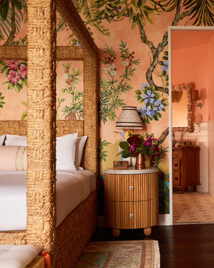 An orange-colored guest room with floral wallpaper