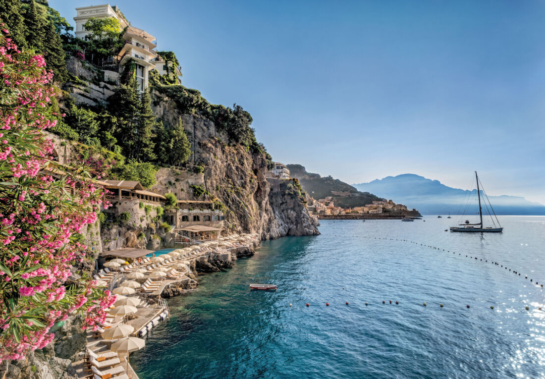 The Amalfi coast, with water and blooming flowers on a cliff