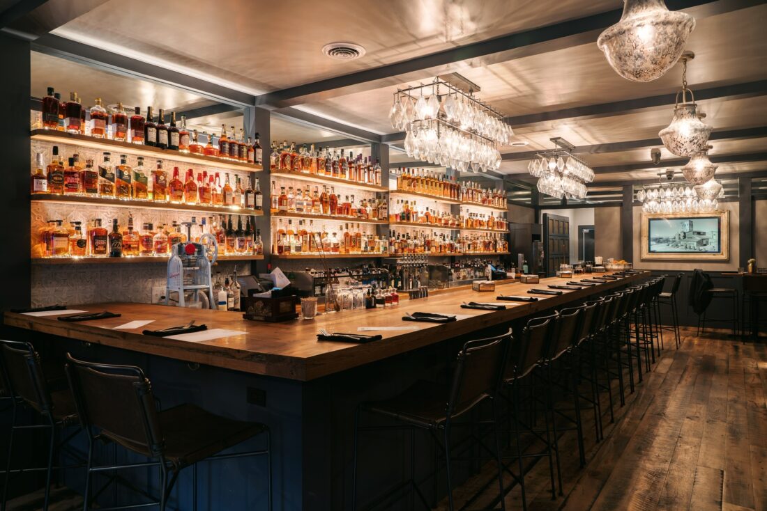 A bar with stocked walls of bourbon