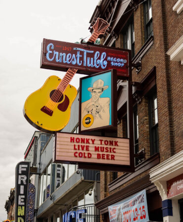 Outside a honky tonk with a neon sign
