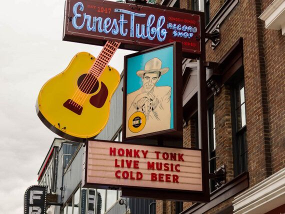 Outside a honky tonk with a neon sign