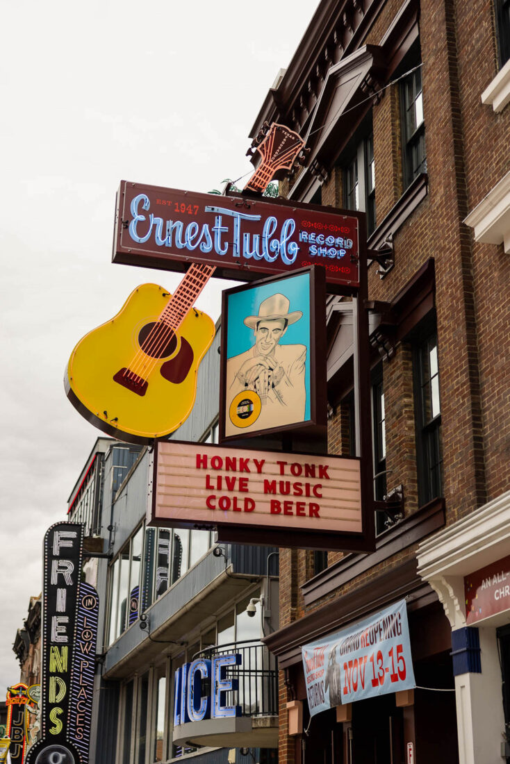 Outside a honky tonk with a neon sign
