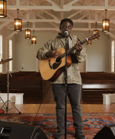 A man on a stage with a guitar