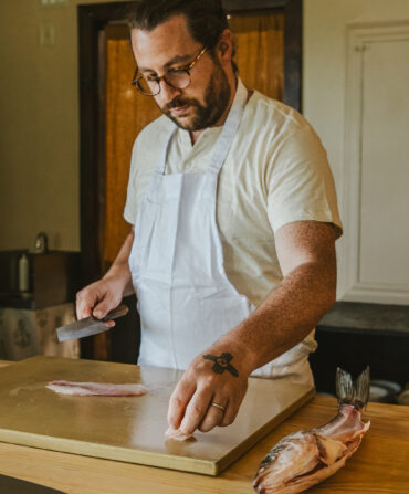 A chef with a fish in a kitchen