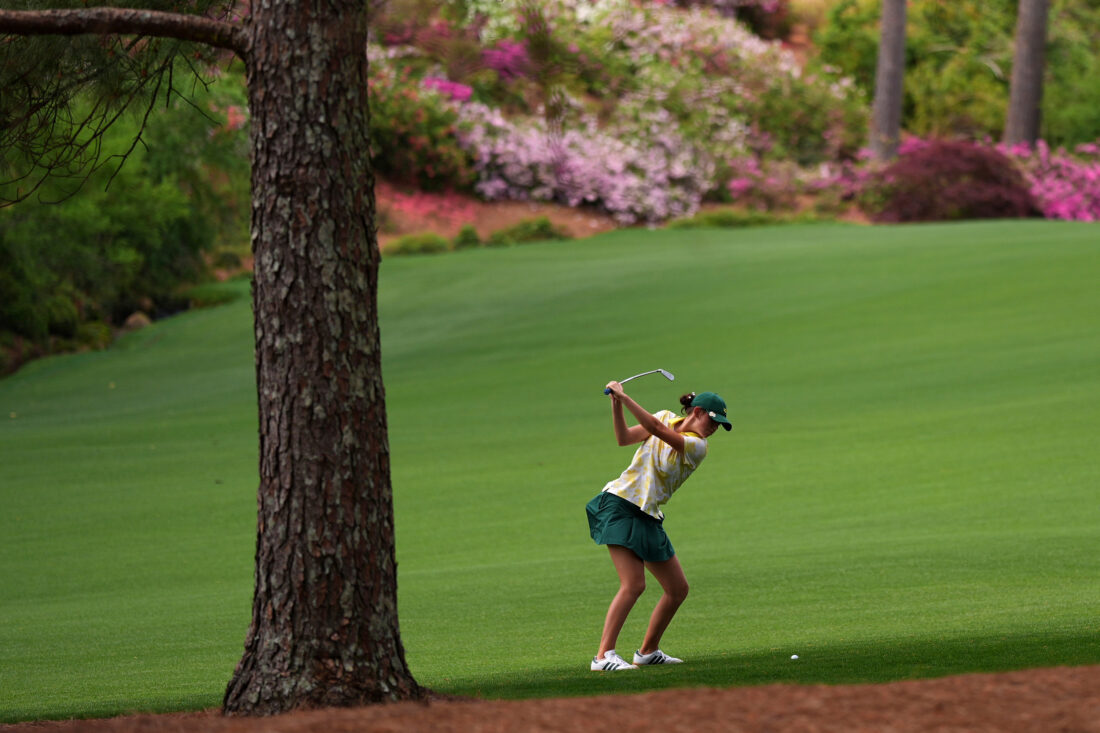 A golfer hitting in a fairway