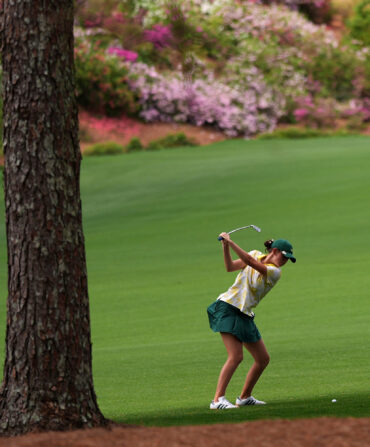 A golfer hitting in a fairway