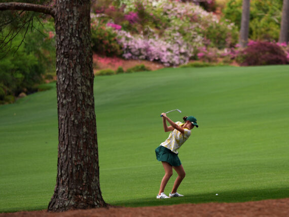 A golfer hitting in a fairway
