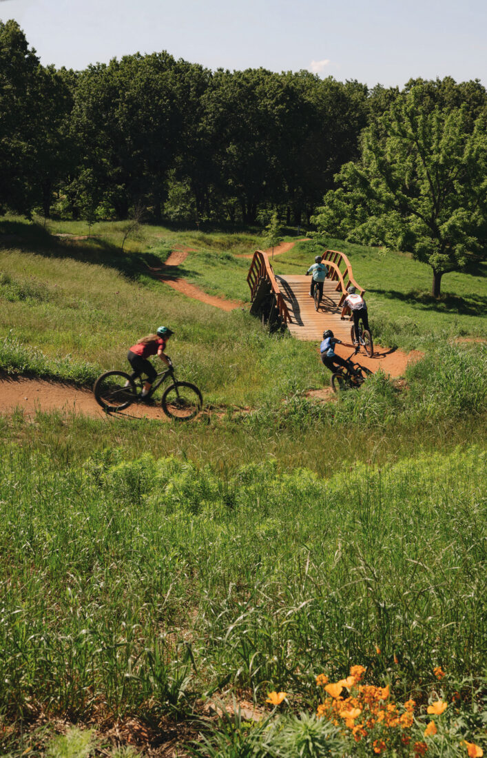 People bike on a dirt trail