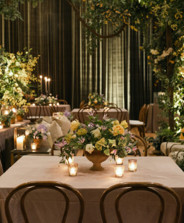 Terra-cotta vessels full of clematis, hellebores, ranunculus, garden roses, and geranium greenery adorned tables.