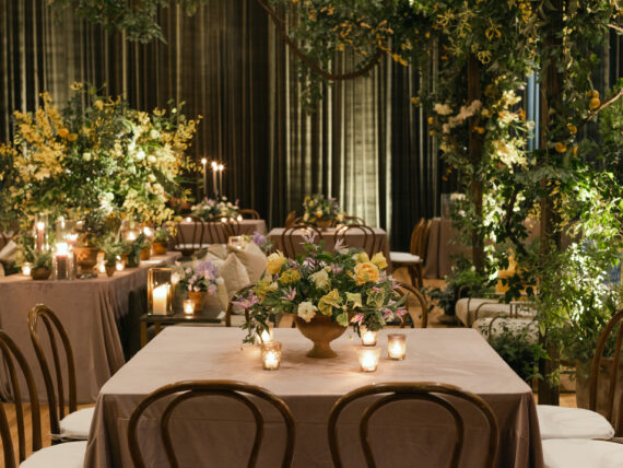 Terra-cotta vessels full of clematis, hellebores, ranunculus, garden roses, and geranium greenery adorned tables.