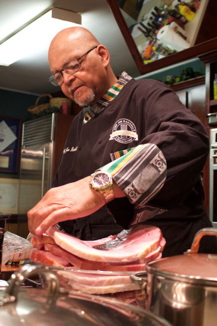 A chef slices ham steaks