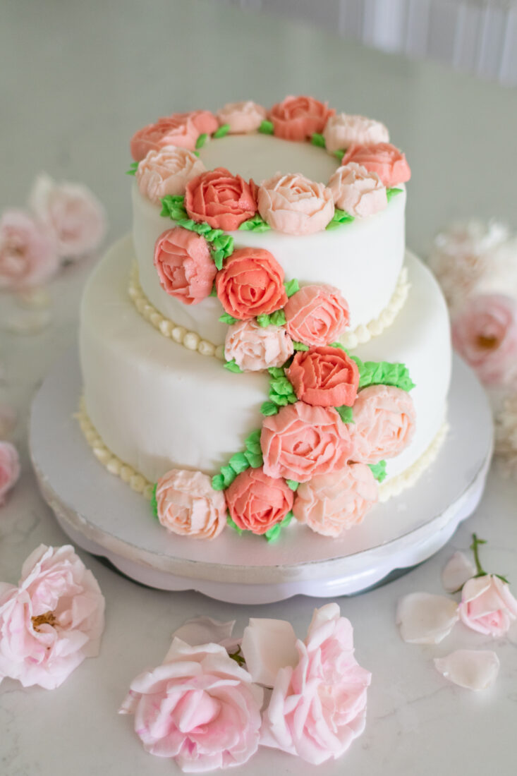 A spring cake decorated with flowers and buttercream icing