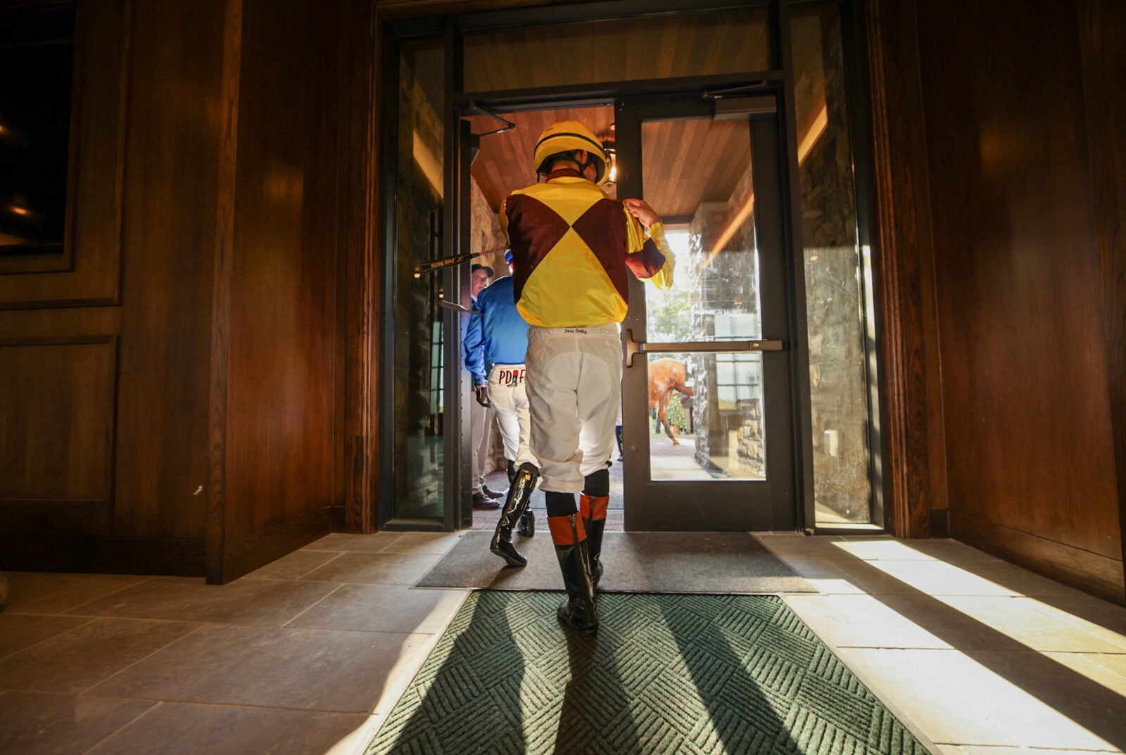 A jockey walking through doors