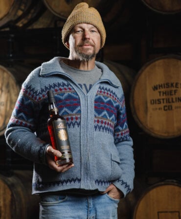 A man holds a bottle of bourbon