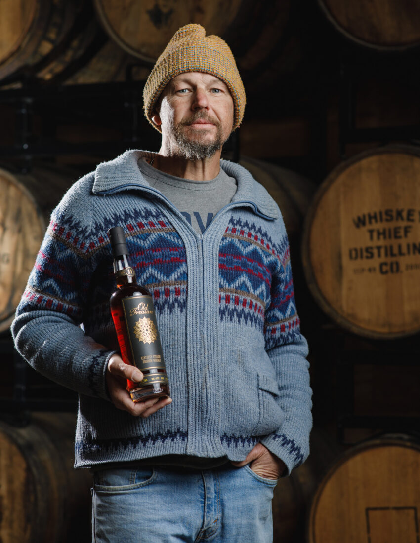 A man holds a bottle of bourbon