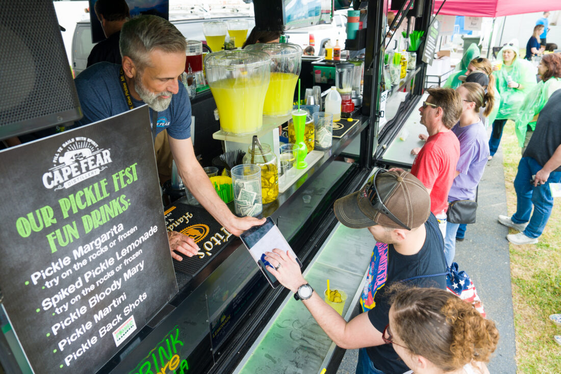 People get drinks at a pickle festival