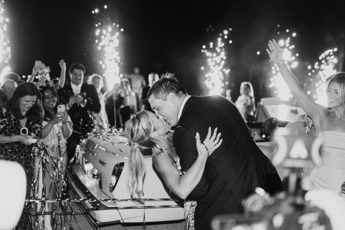 A wedding couple kisses at a party