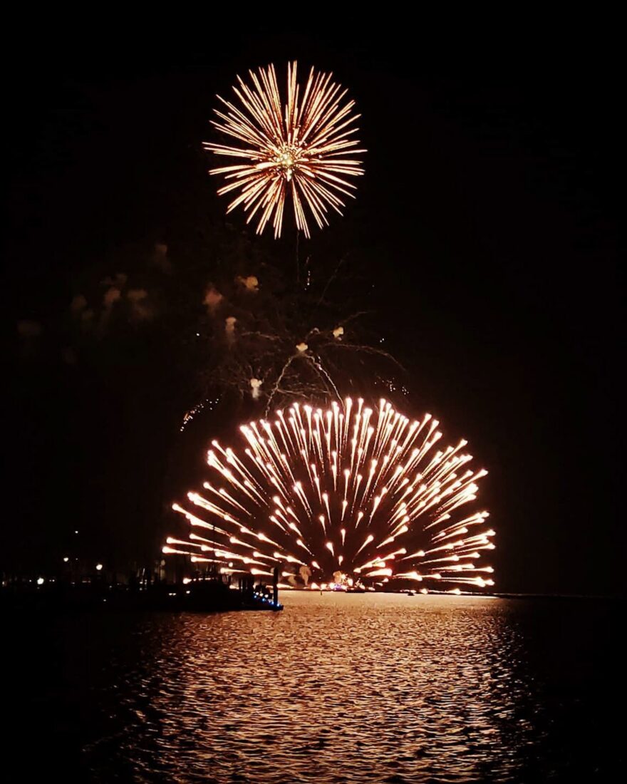 Fireworks at night over a bay