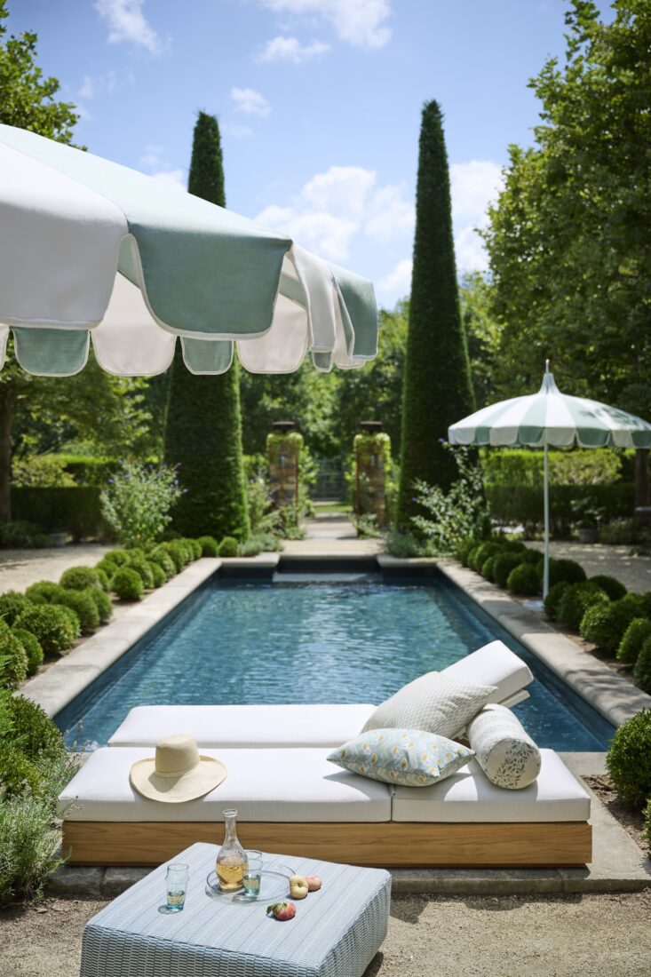 A pool and lounger with umbrellas