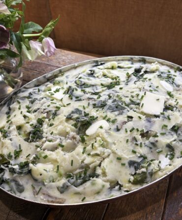 Mashed skin-on russet potatoes and steamed chopped collards blended with chicken stock, milk, butter, and scallions and garnished with chives and more butter