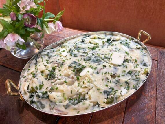 Mashed skin-on russet potatoes and steamed chopped collards blended with chicken stock, milk, butter, and scallions and garnished with chives and more butter