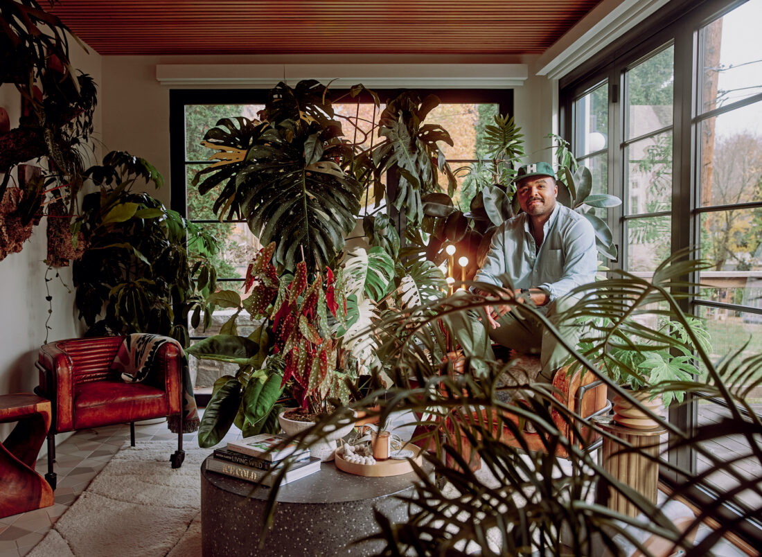 A man in a sunroom with plants