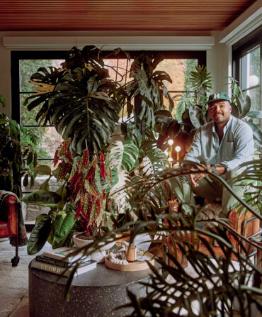 A man in a sunroom with plants